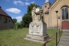 Gradzko... przed którym znajdują się dwa klasycystyczne pomniki nagrobne z początku XIX wieku.